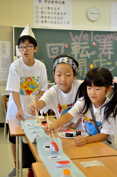 紙でできた寿司を制限時間内につかみ数を競う「回転寿司」で楽しむ子どもたち