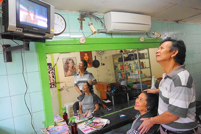 美容室の主人と客もテレビの選挙放送に興味津々=午前10時15分、中央ジャカルタのタナアバン