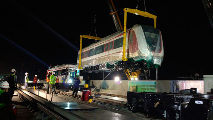24日未明、大型クレーンでつり下ろされる車両