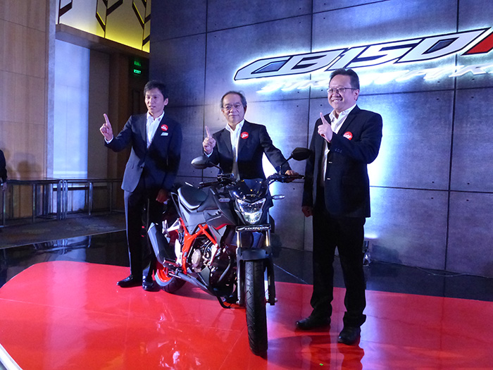 新型「CB150R ストリートファイヤー」を発表する井沼社長(中央)ら