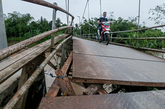 ▼崩壊寸前の橋を通るバイク